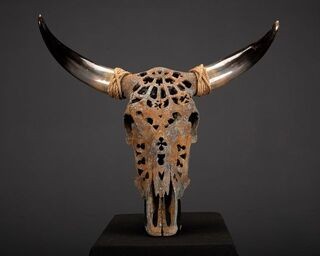 A beautiful carved Nguni skull with oxidized metal powders creating a rustic and aged finish t...jpg