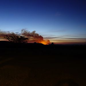 In the distance, a bush fire burns